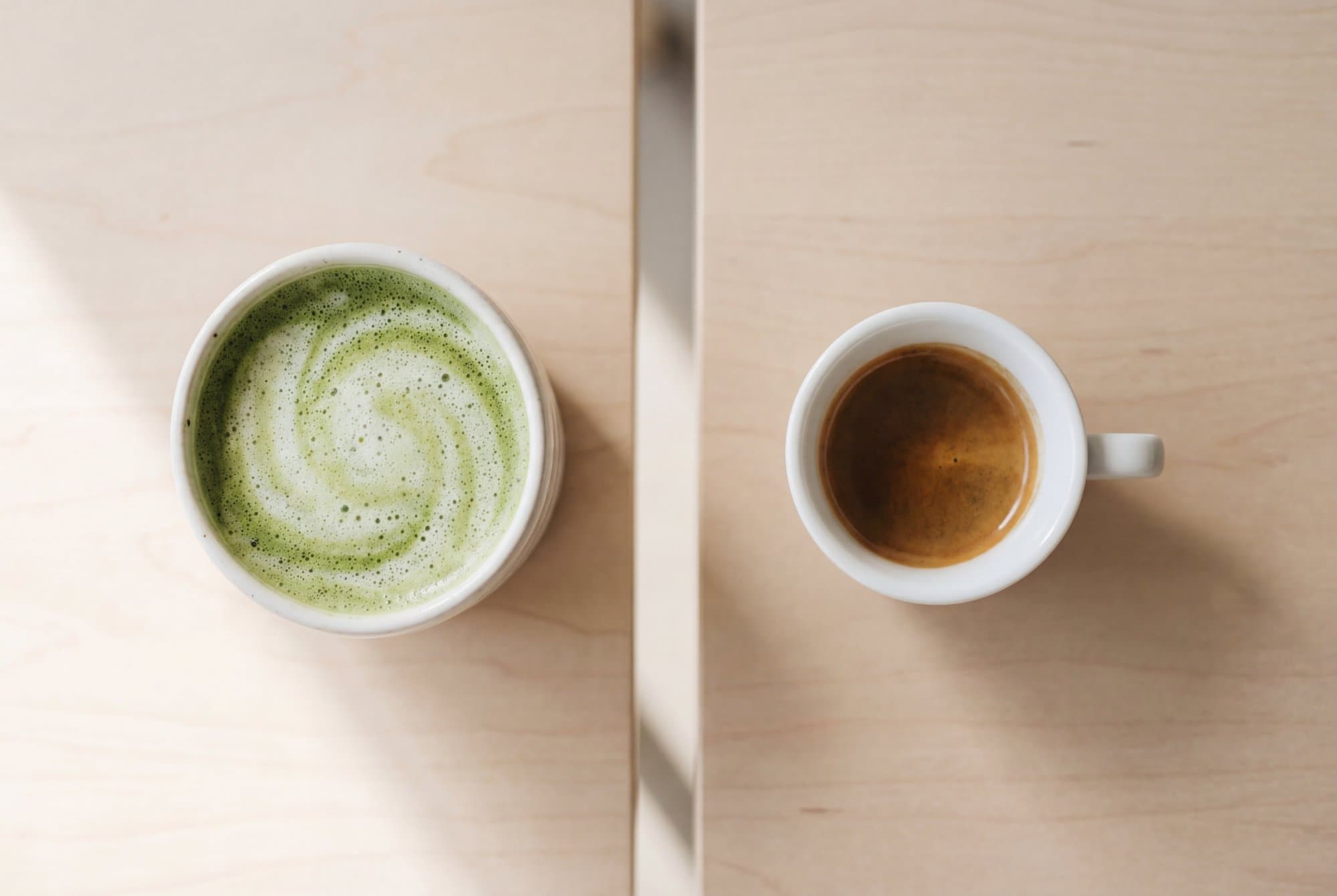 Matcha vs koffie vergelijking - groene matcha poeder naast koffiebonen